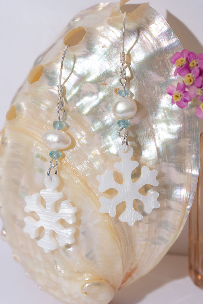 A snowflake on a South Pacific island, imagine that and this pretty carved mother of pearl snowflake has a tiny sparkling sky blue Topaz bead as a highlight so dream on wearing our newest earring style.