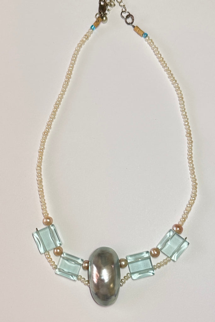This pretty necklace is a one off piece made exclusively for Mombasa Rose Boutique. The centrepiece is a dome of silvery grey mother of pearl shell. The necklace is of cream natural pearls. 