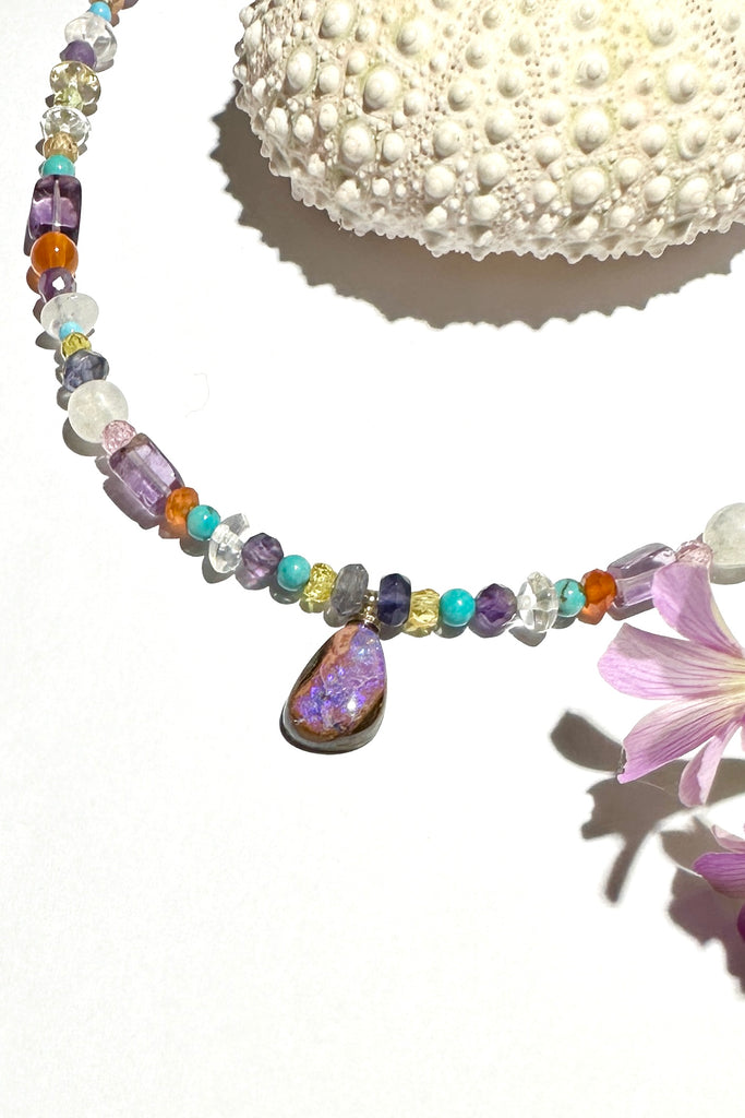 So pretty and modern, this teeny tiny opal is the centrepiece on a multi stone bead gemstone necklace that sparkles in the light.&nbsp;  This Australian opal has a pool of earthy blueish mauve down the centre. The necklace is made from many gemstone seed beads, including natural Turquoise, Howlite, Amethyst, Citrine, Flourite,Carnelian and more.