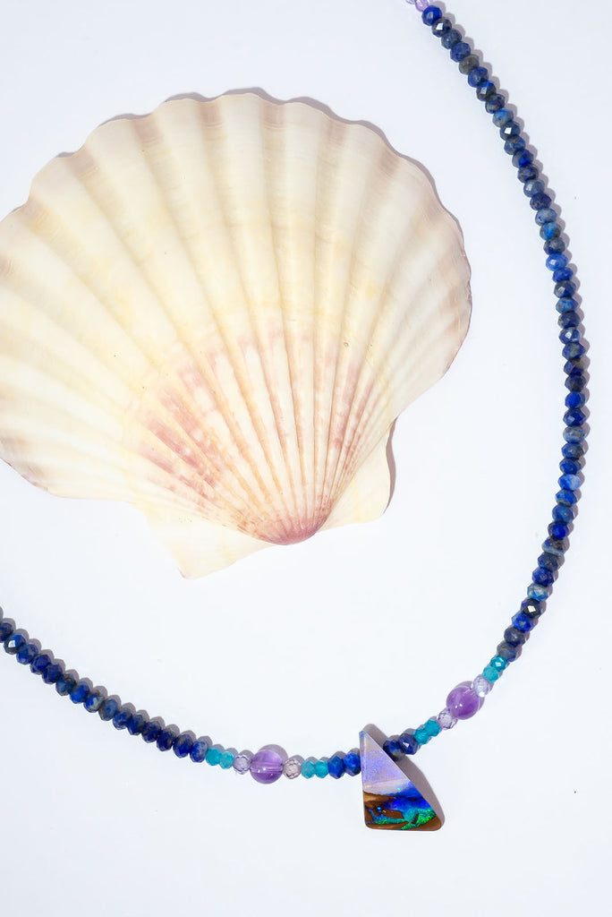 A bright splash of blue, a river of brightest green and an amethyst sky. A solid opal with the intensity of bright colour that is absolutely unique, on a deep blue Lapis Lazuli faceted bead necklace.