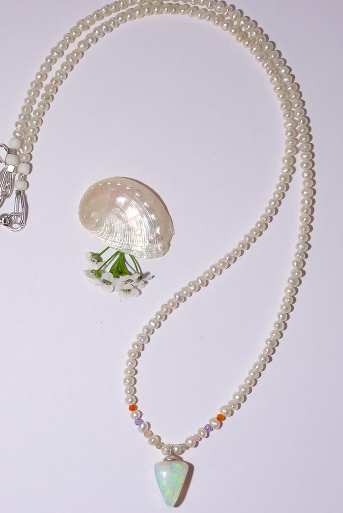 A pearl necklace with twist, we have added a tiny luminous crystal opal as the centrepiece.