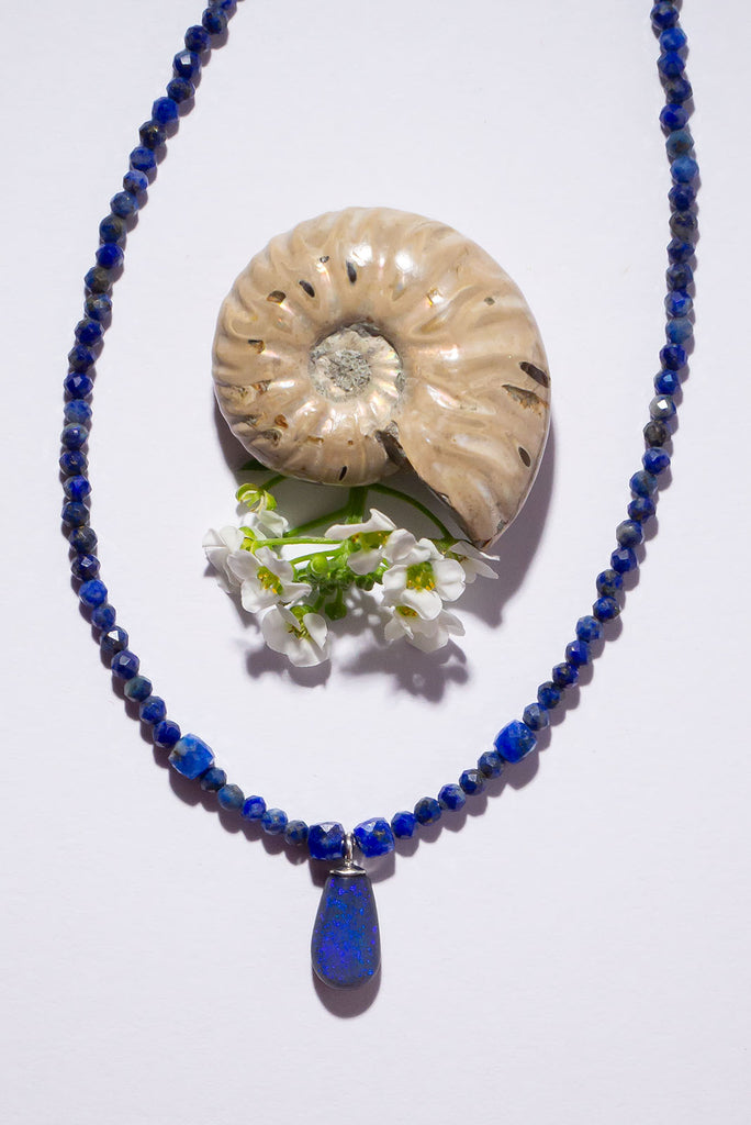 A bright splash of blue, a solid black opal with the intensity of bright cobalt blue deep in the stone, on a deep blue Lapis Lazuli tiny faceted bead necklace.