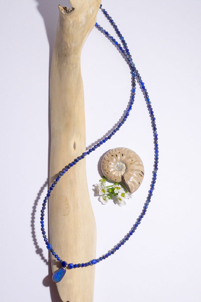 A bright splash of blue, a solid black opal with the intensity of bright cobalt blue deep in the stone, on a deep blue Lapis Lazuli tiny faceted bead necklace.