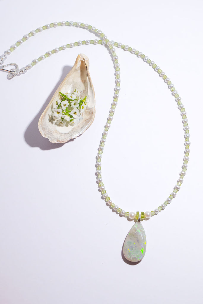 Peridot and Pearls, green, gold and blue flashes across the opal in a magical dance of colour. So mystical and chic.