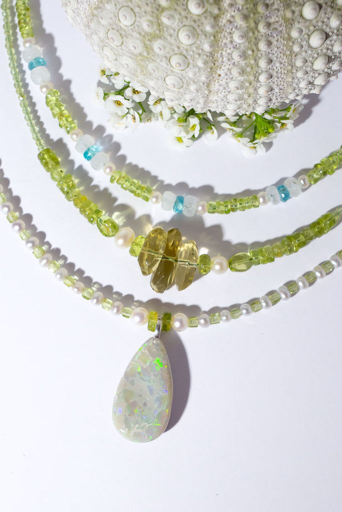 Peridot and Pearls, green, gold and blue flashes across the opal in a magical dance of colour. So mystical and chic.