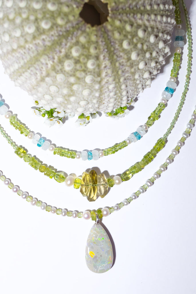 Peridot and Pearls, green, gold and blue flashes across the opal in a magical dance of colour. So mystical and chic.