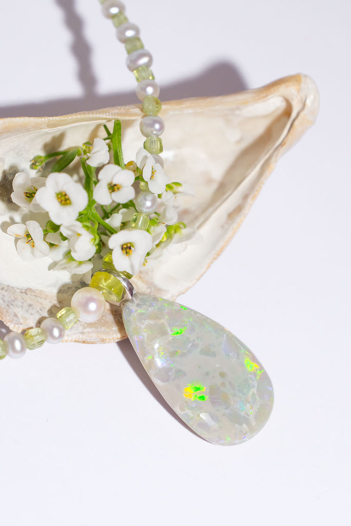 Peridot and Pearls, green, gold and blue flashes across the opal in a magical dance of colour. So mystical and chic.