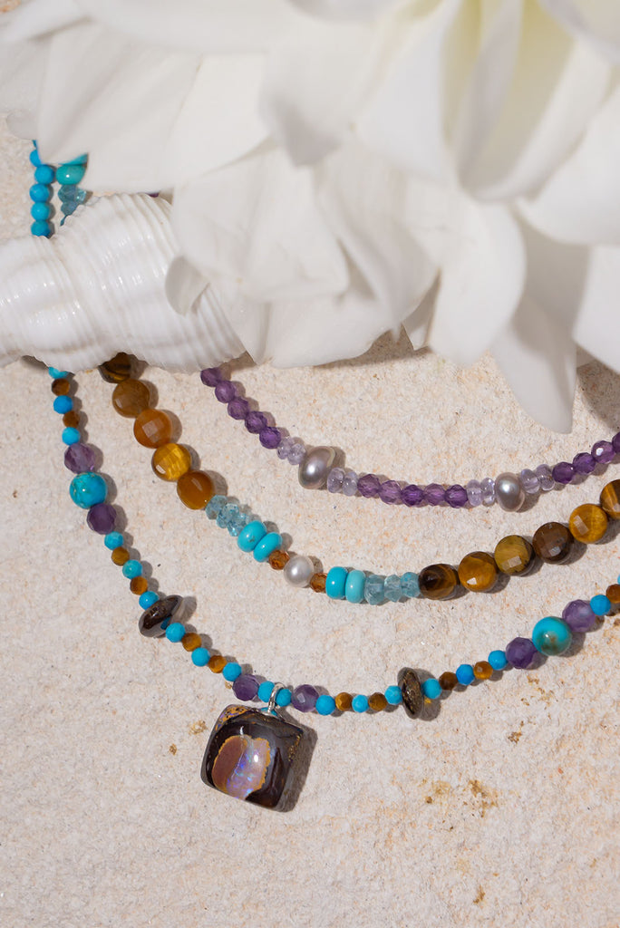 Pretty, modern and sparkly, a tiny opal is the centrepiece on a bright multi stone bead gemstone necklace that glitters in the light.