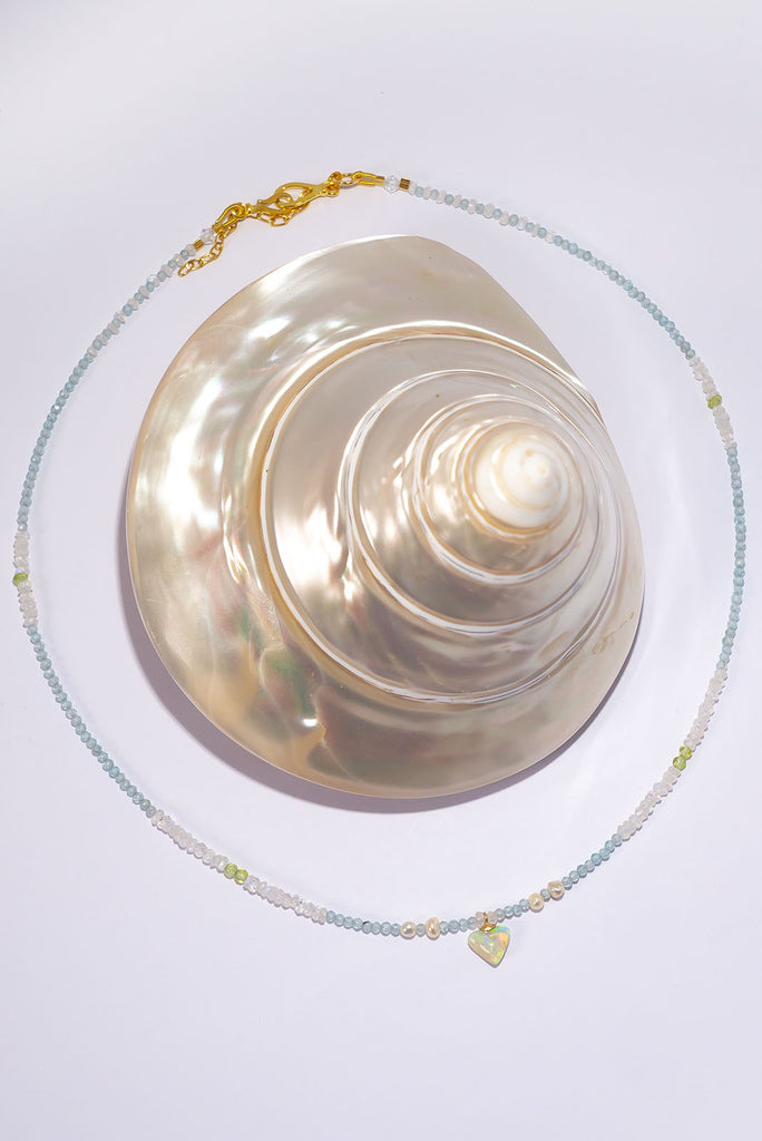 This delicate necklace features clear icy tones and a magical shimmering petite crystal opal pendant.