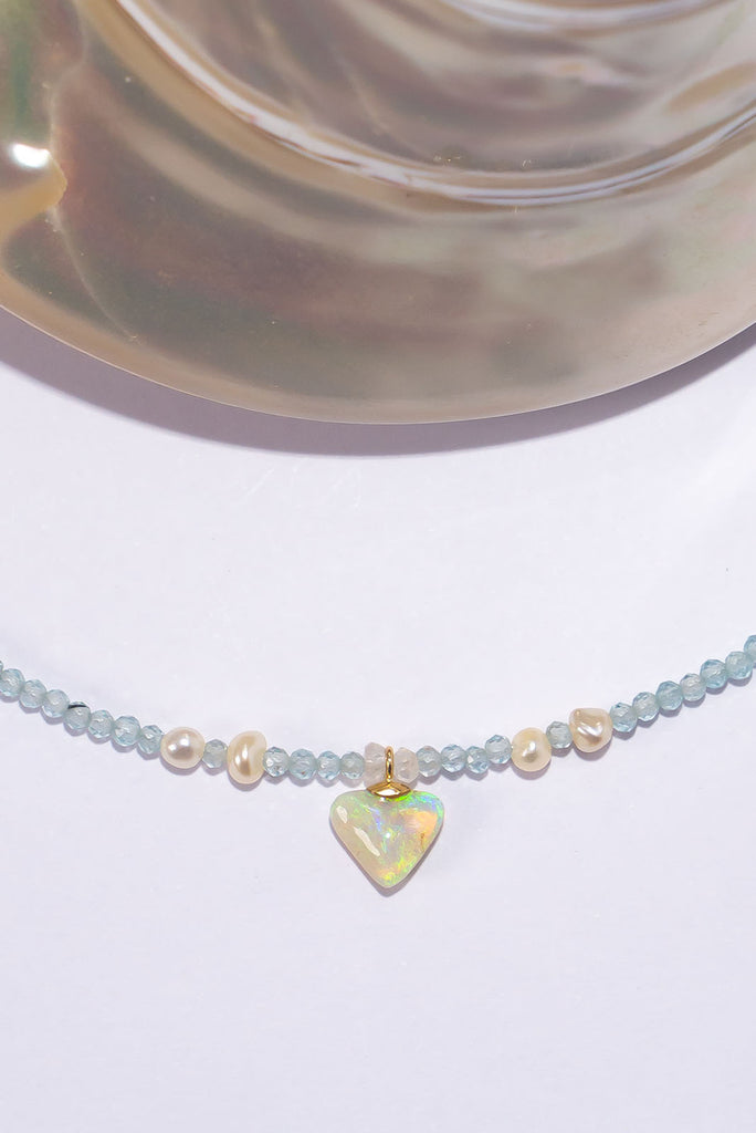 This delicate necklace features clear icy tones and a magical shimmering petite crystal opal pendant.