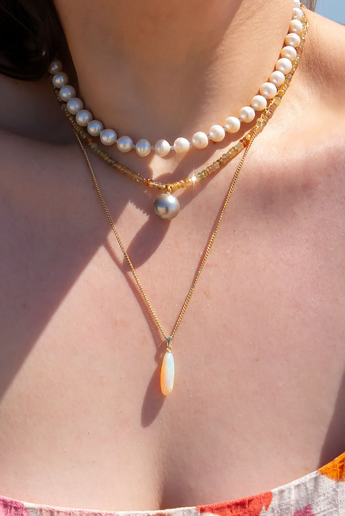 A gorgeous warm grey pearl sits amongst a sparkling strand of multi toned zircons. This piece truly shimmers in the sunlight.