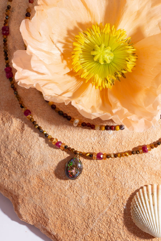 This warm toned shimmering gemstone necklace features a petite but special Australian boulder opal filled with a rainbow of colour play.