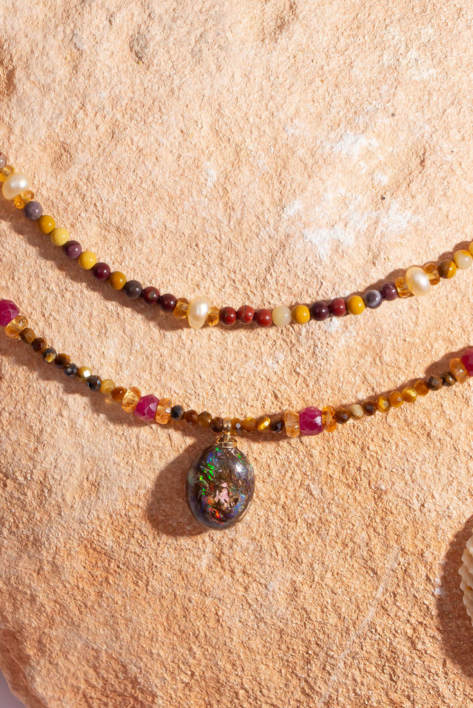 This warm toned shimmering gemstone necklace features a petite but special Australian boulder opal filled with a rainbow of colour play.