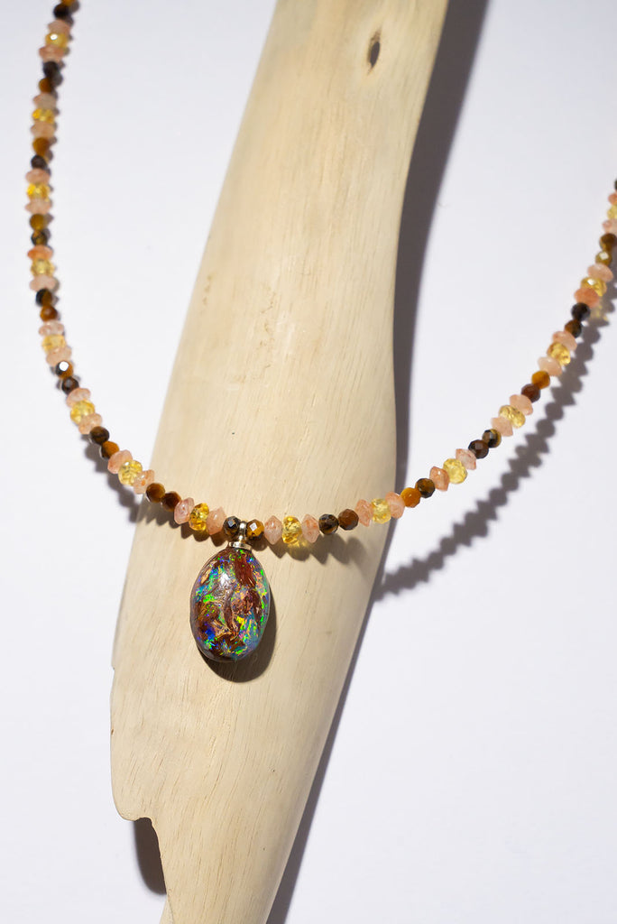 The stunning colour play of this exceptional matrix opal pendant colour play is complimented beautifully by the sunshine hues of yellow sapphire & natural sunstone.