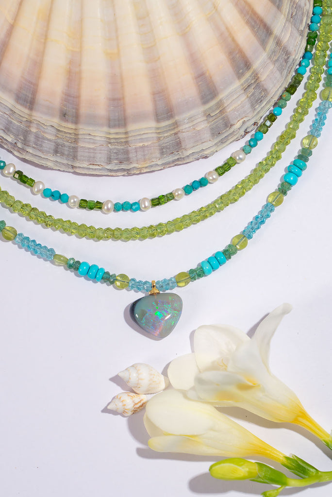 Like waters swirling around outskirts of a tropical reef this captivating necklace features enchanting shades of blue and sea green and the gorgeous semi black opal pendant adds a touch of magic.