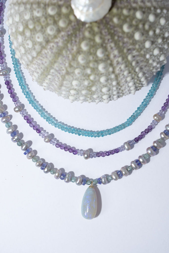 Misty grey, periwinkle blue, aquamarine and a luminous Australian opal come together to create an ethereal gemstone necklace.