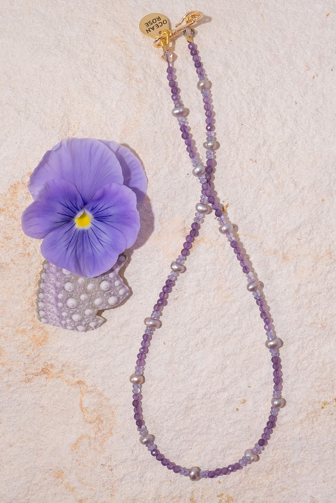 The prettiest purple necklace around. This delicate piece features soft shades of lilac & lavender and is elevated by beautiful shimmer soft grey pearls.