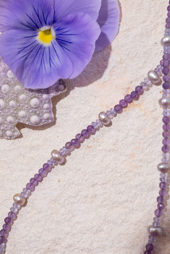 The prettiest purple necklace around. This delicate piece features soft shades of lilac & lavender and is elevated by beautiful shimmer soft grey pearls.