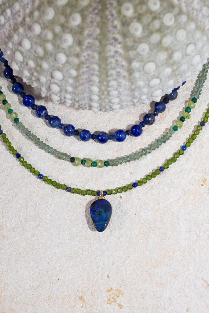 This delicate gemstone necklace features showing stopping jewel tones and a petite boulder opal pendant.