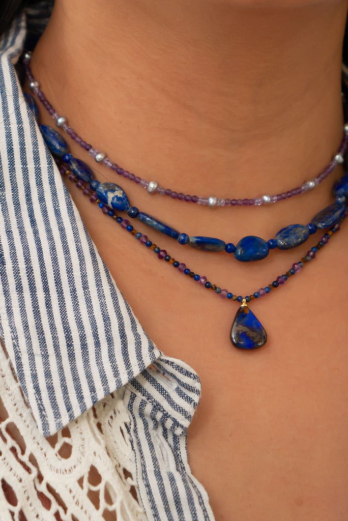 With beautiful pools of dark blue colour play found within the deep brown boulder stone this enthralling opal is complimented by the jewel tones of amethyst, lapis lazuli &amp; shimmering tigers eye.