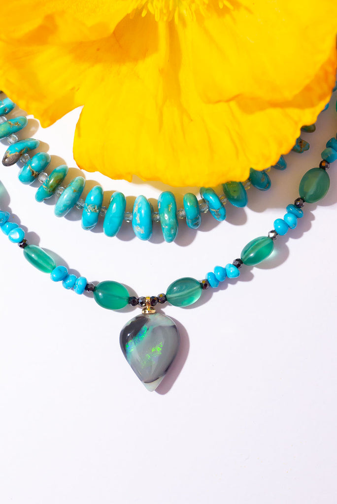 With gorgeous bubbles of green onyx, intense sky-blue Sleeping Beauty turquoise and a luminous black opal with shimmering streaks of green and aqua colour play this is a truly enchanting piece.