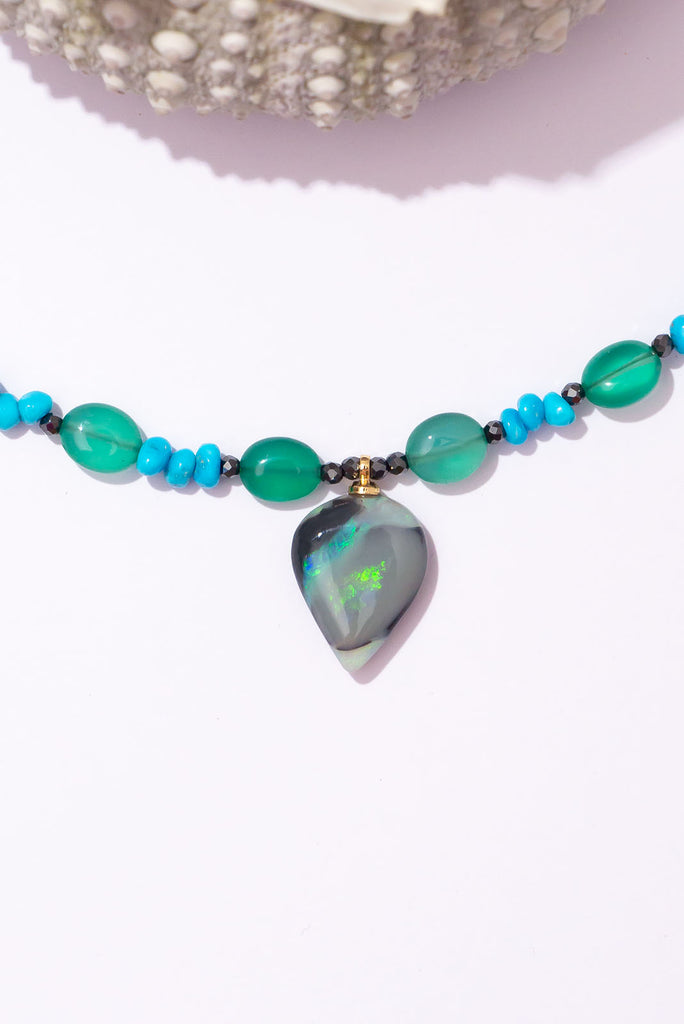 With gorgeous bubbles of green onyx, intense sky-blue Sleeping Beauty turquoise and a luminous black opal with shimmering streaks of green and aqua colour play this is a truly enchanting piece.