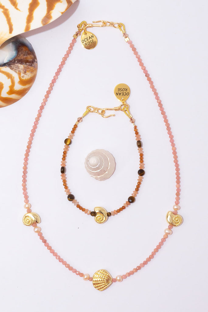 This delicate strand of peachy pink gemstones & golden glowing shells is the perfect necklace to wear on its own or as a beautiful pop of colour in your next necklace stack.