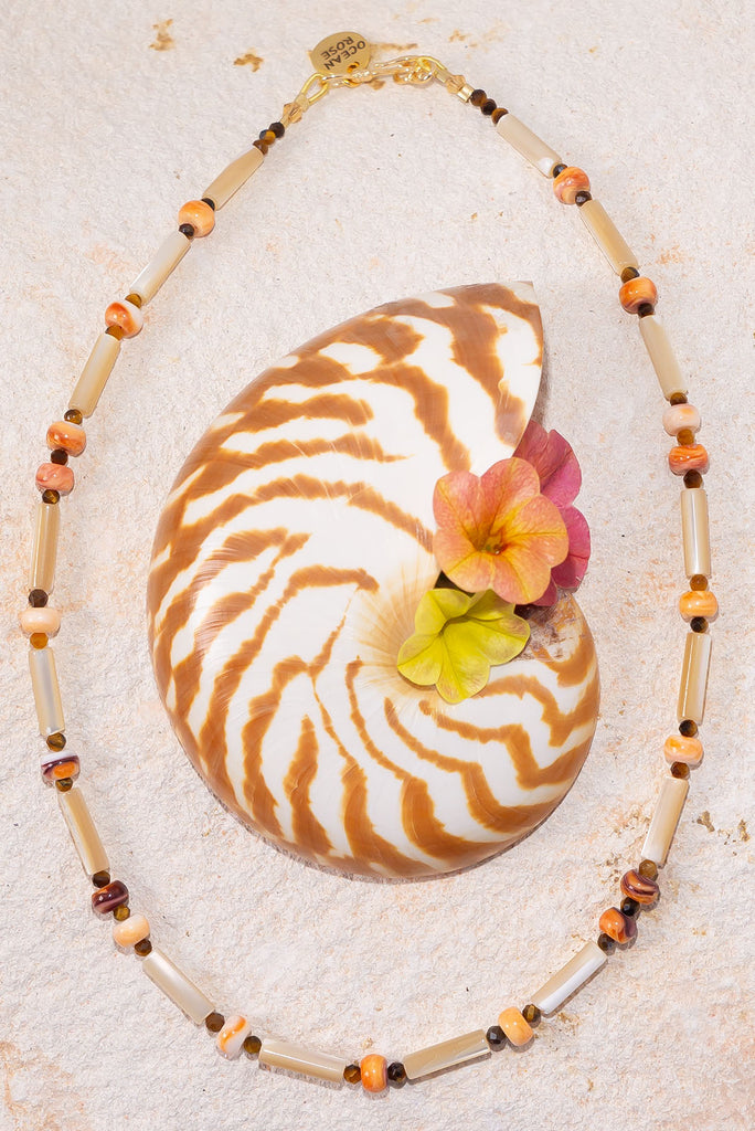 This gorgeous necklace features warm spice tones and shimmering creamy mother of pearl.