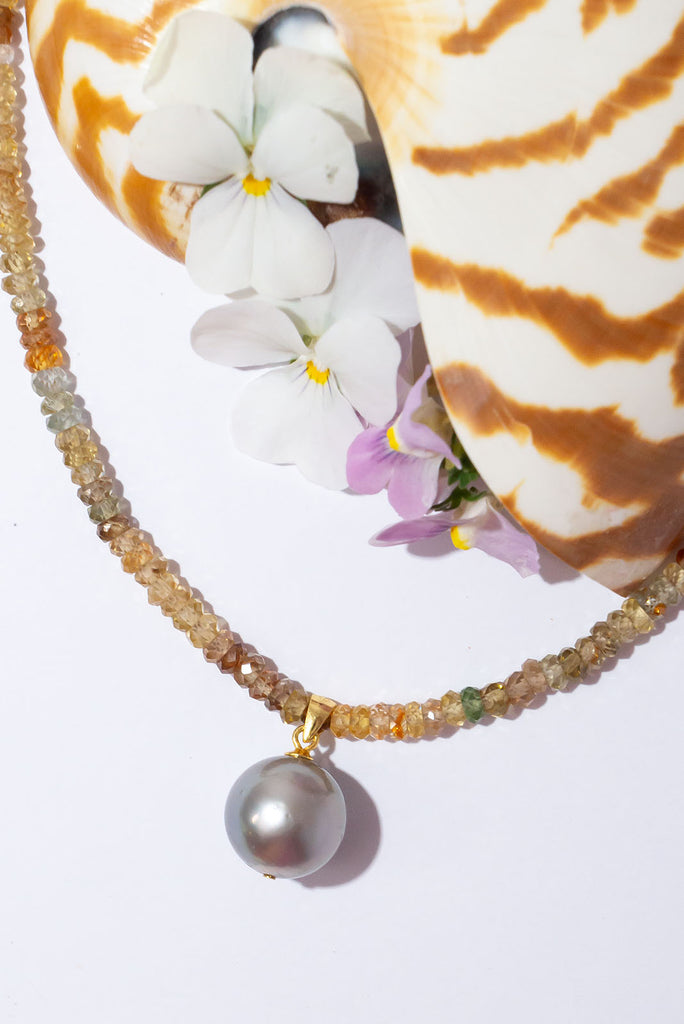 A gorgeous warm grey pearl sits amongst a sparkling strand of multi toned zircons. This piece truly shimmers in the sunlight.