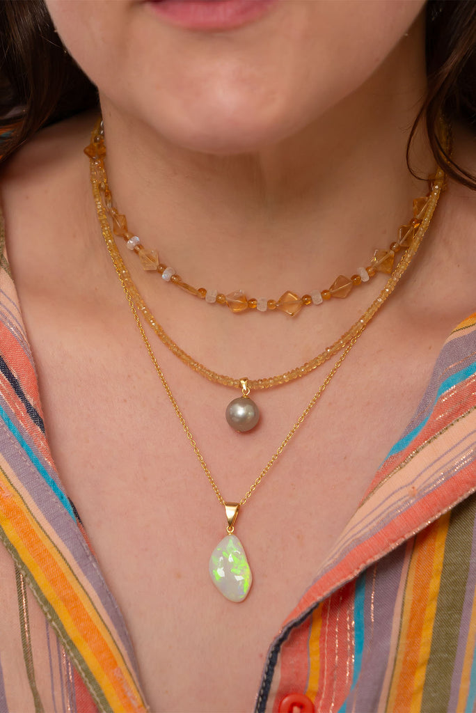 This warm toned shimmering gemstone necklace features a petite but special Australian boulder opal filled with a rainbow of colour play.