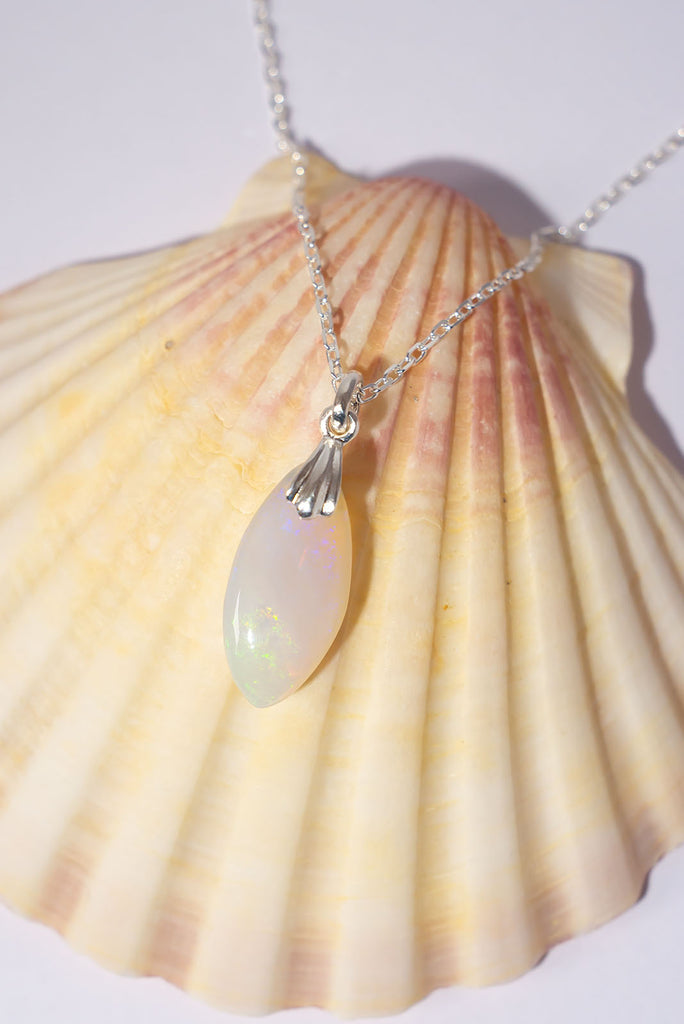 This delicate white opal pendant has scattering of colour play like a rainbow reflecting on a frozen pool.