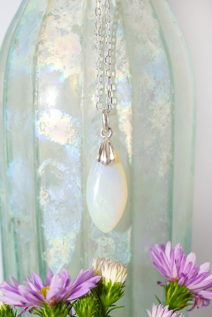 This delicate white opal pendant has scattering of colour play like a rainbow reflecting on a frozen pool.