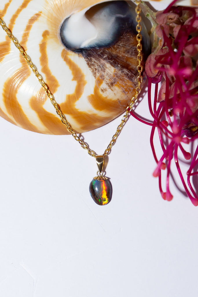 This petite Australian Boulder Opal pendant has extraordinary broad pattern colour flashes predominately green, gold & red. It is a truly special piece.