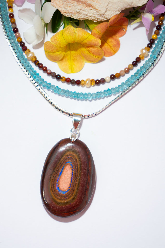 Like the walls of an outback gully as they slope down to a sparkling blue river below. This standout Australian Boulder Opal pendant was cut, polished and set in Noosa, Queensland from 100% Australian Opal.