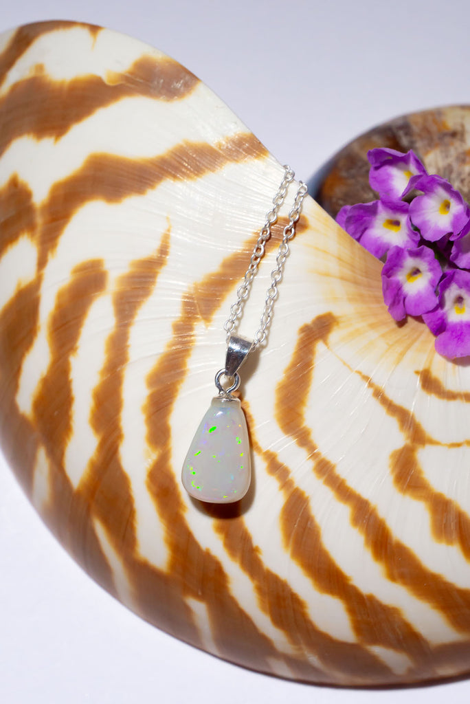 A tiny luminous crystal cloud with green and mauve confetti flashes, this pretty little opal pendant will look divine in sunlight.