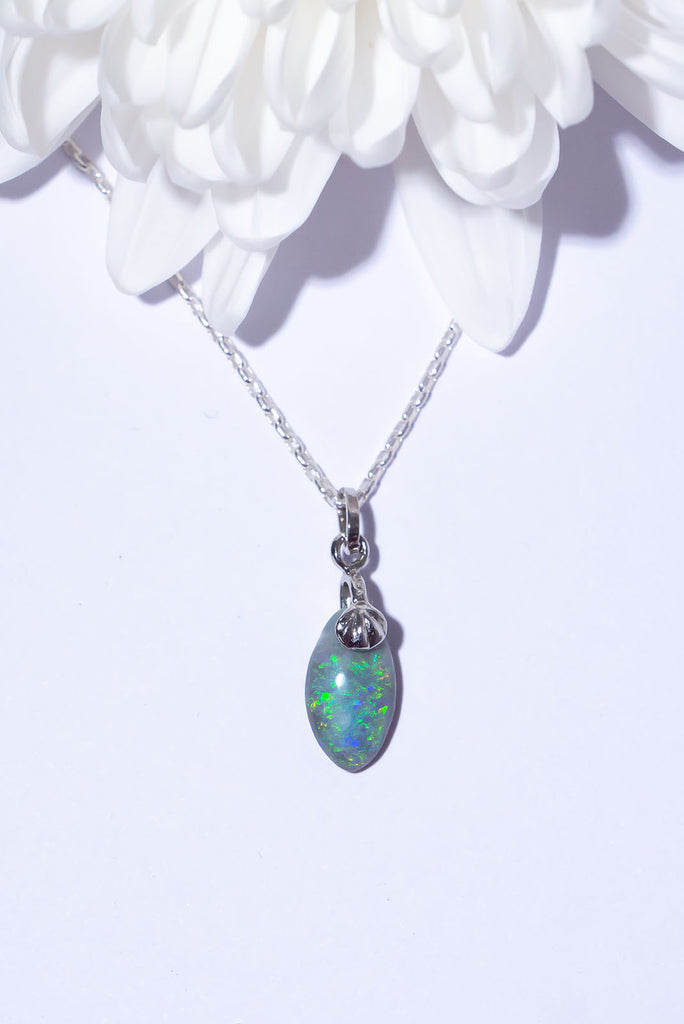 A beautiful droplet of Australian Opal with a sparkling swirl of green colour play with flecks of blue & gold.