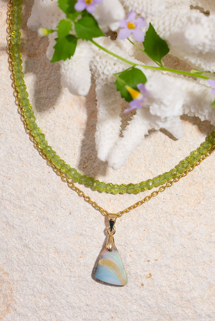 Echoing the gentle curve of a sandbank flowing out to sea, this sweet and subtle opal pendant has soft swirling shades of green and a little pink.