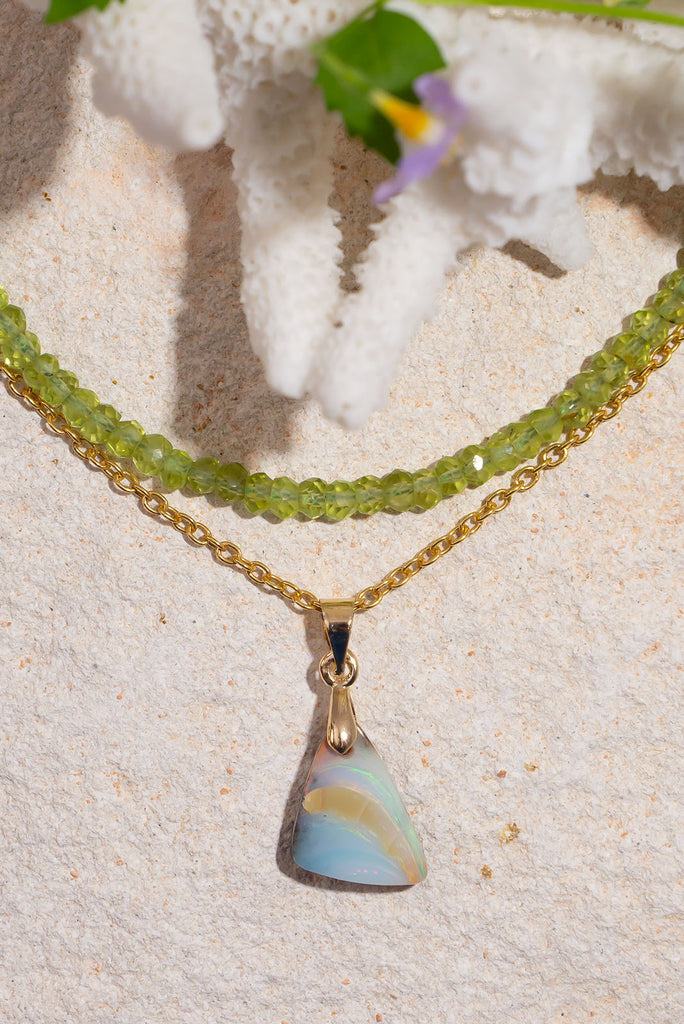 Echoing the gentle curve of a sandbank flowing out to sea, this sweet and subtle opal pendant has soft swirling shades of green and a little pink.