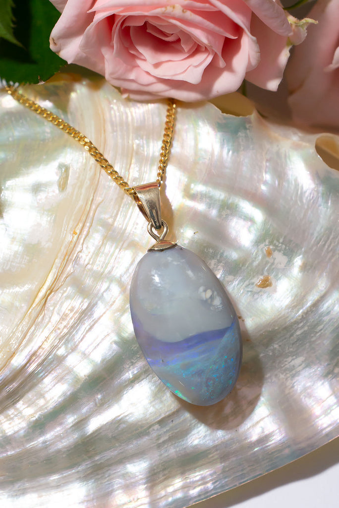 This delicate Australian opal pendant is reminiscent of a swirling sea fog as it meets the land. With a beautiful pool of shimmering colour play and a sky of softest grey.