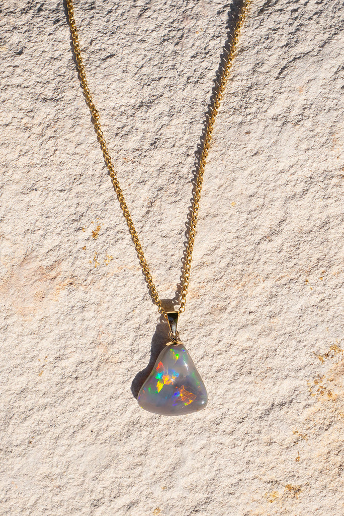 With a different rainbow of colour from every direction this exceptional opal pendant follows the natural undulations of the original stone rough to create the most intense pattern of rainbow colour play.