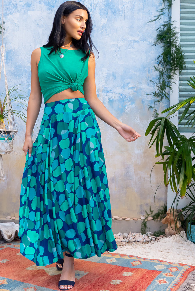 The Atlantis Emerald Zinzi Maxi Skirt  features double V-shaped waist yoke, inset panels from the yoke down, very full skirt, elasticated & ruched back of waist, side pockets and woven 100% Viscose in navy base with blue and green spots.