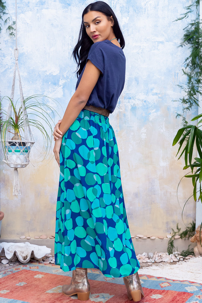 The Atlantis Emerald Zinzi Maxi Skirt features double V-shaped waist yoke, inset panels from the yoke down, very full skirt, elasticated & ruched back of waist, side pockets and woven 100% Viscose in navy base with blue and green spots.