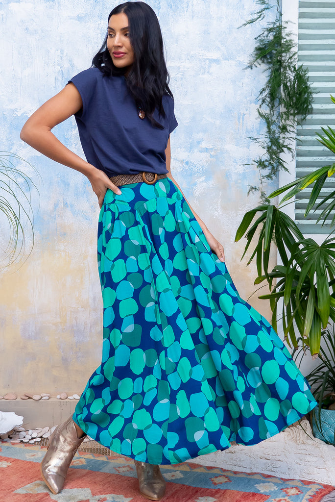 The Atlantis Emerald Zinzi Maxi Skirt features double V-shaped waist yoke, inset panels from the yoke down, very full skirt, elasticated & ruched back of waist, side pockets and woven 100% Viscose in navy base with blue and green spots.